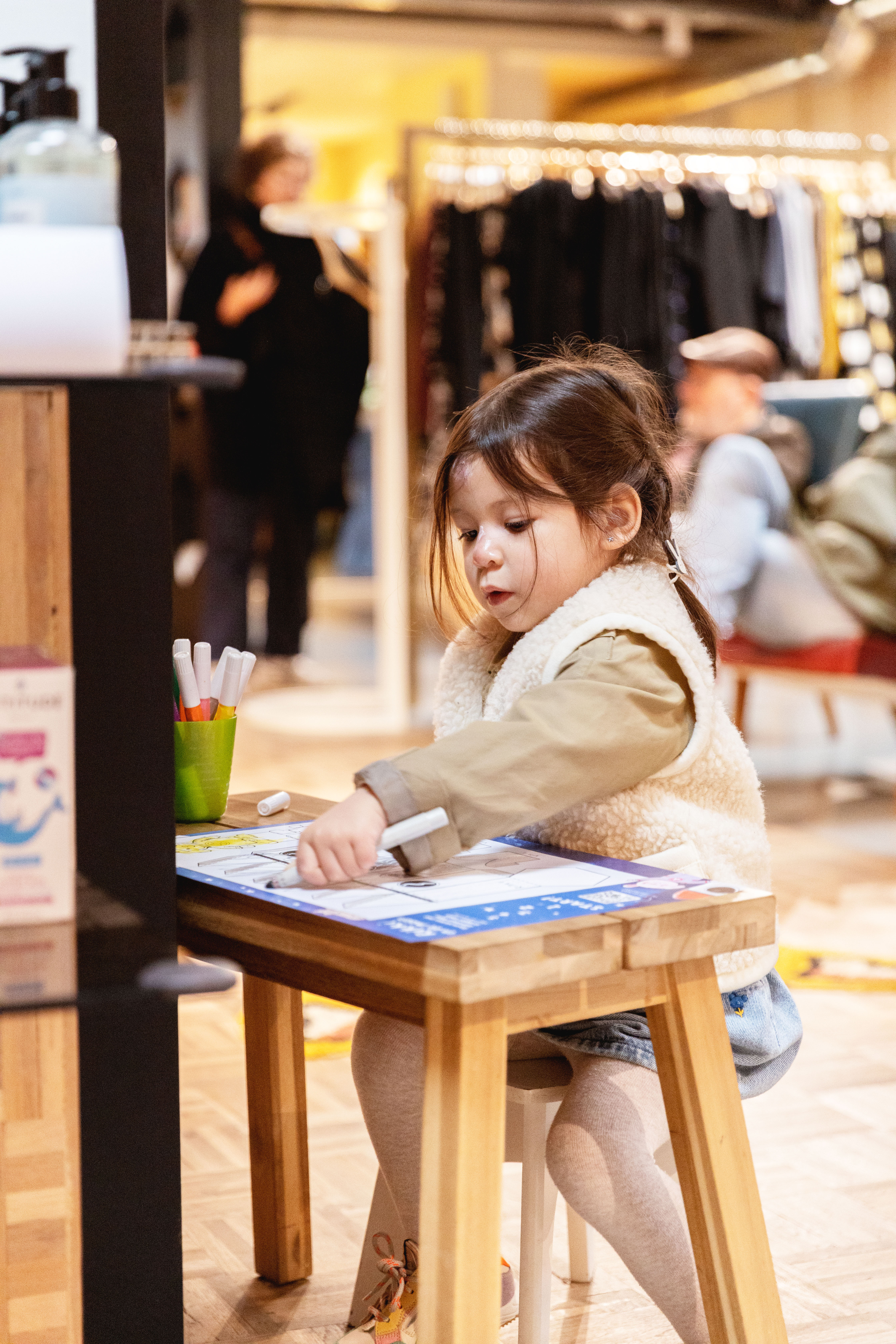 Een kleuter knutselt een Rikki-raket in Paplou. Ze zit aan een tafeltje de raket in te kleuren.
