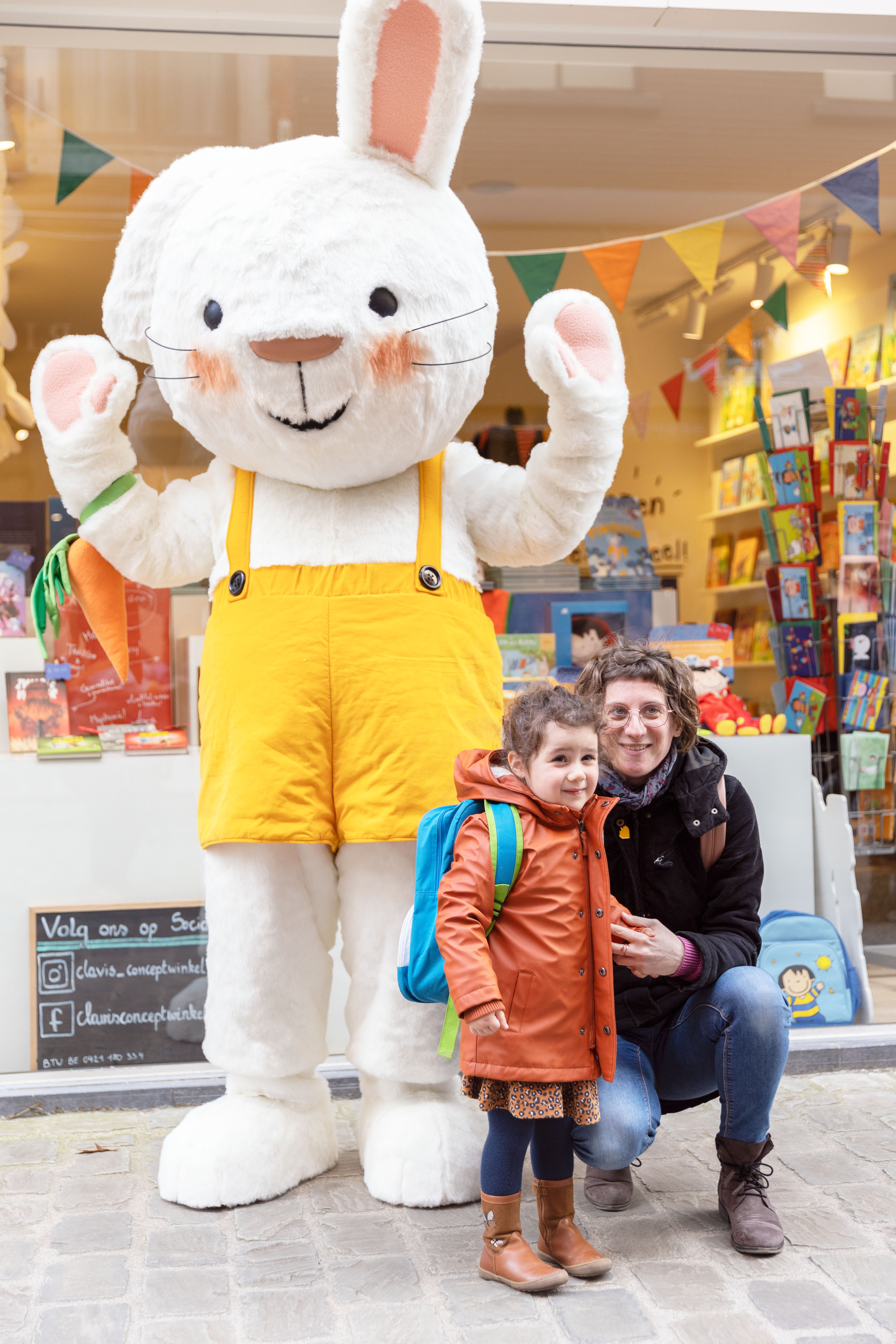 Een foto van een mama die samen met haar dochter op de foto gaat met Rikki voor de Clavis Conceptwinkel Hasselt.