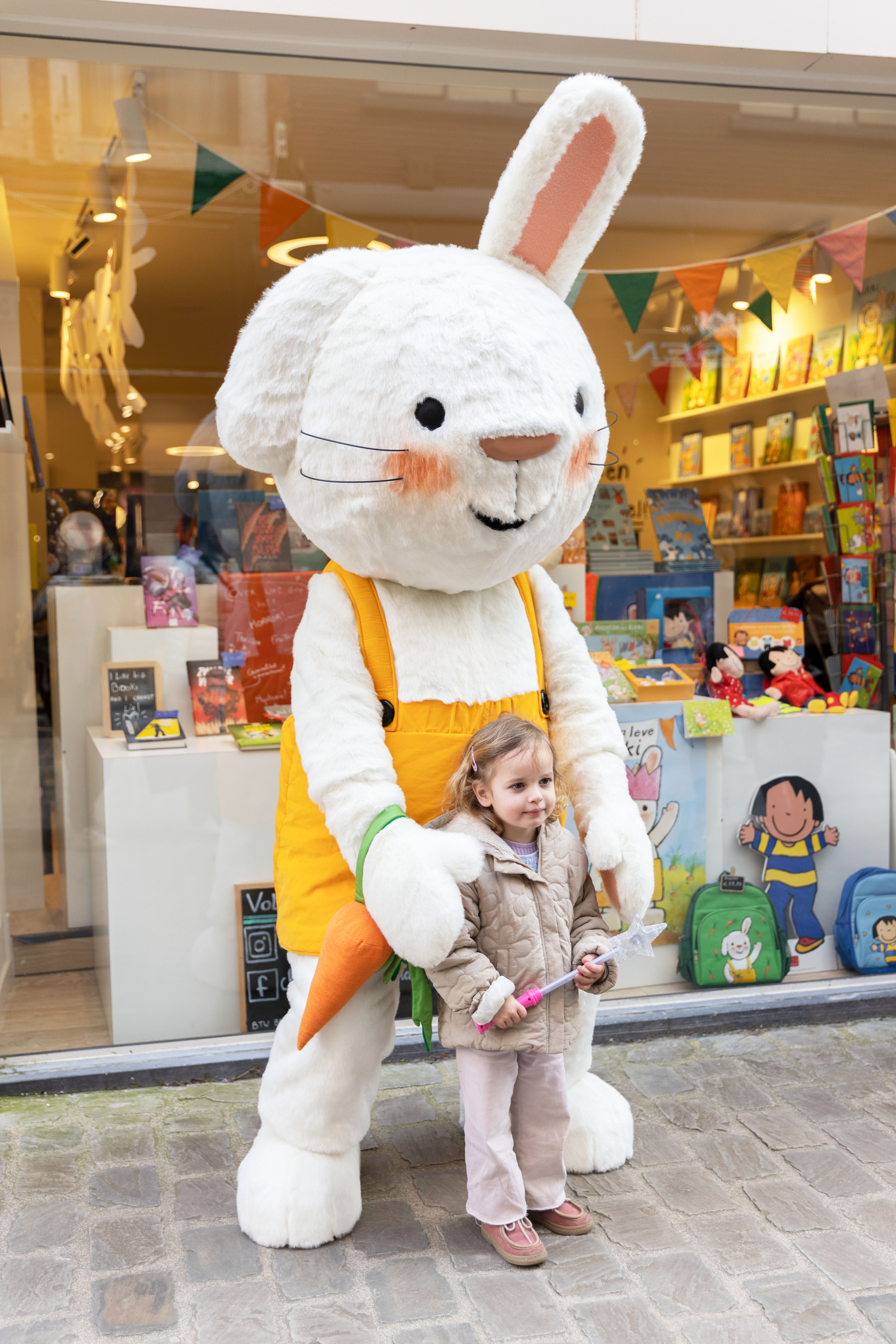 Een foto van een meisje dat poseert met Rikki voor de Clavis Conceptwinkel in Hasselt.