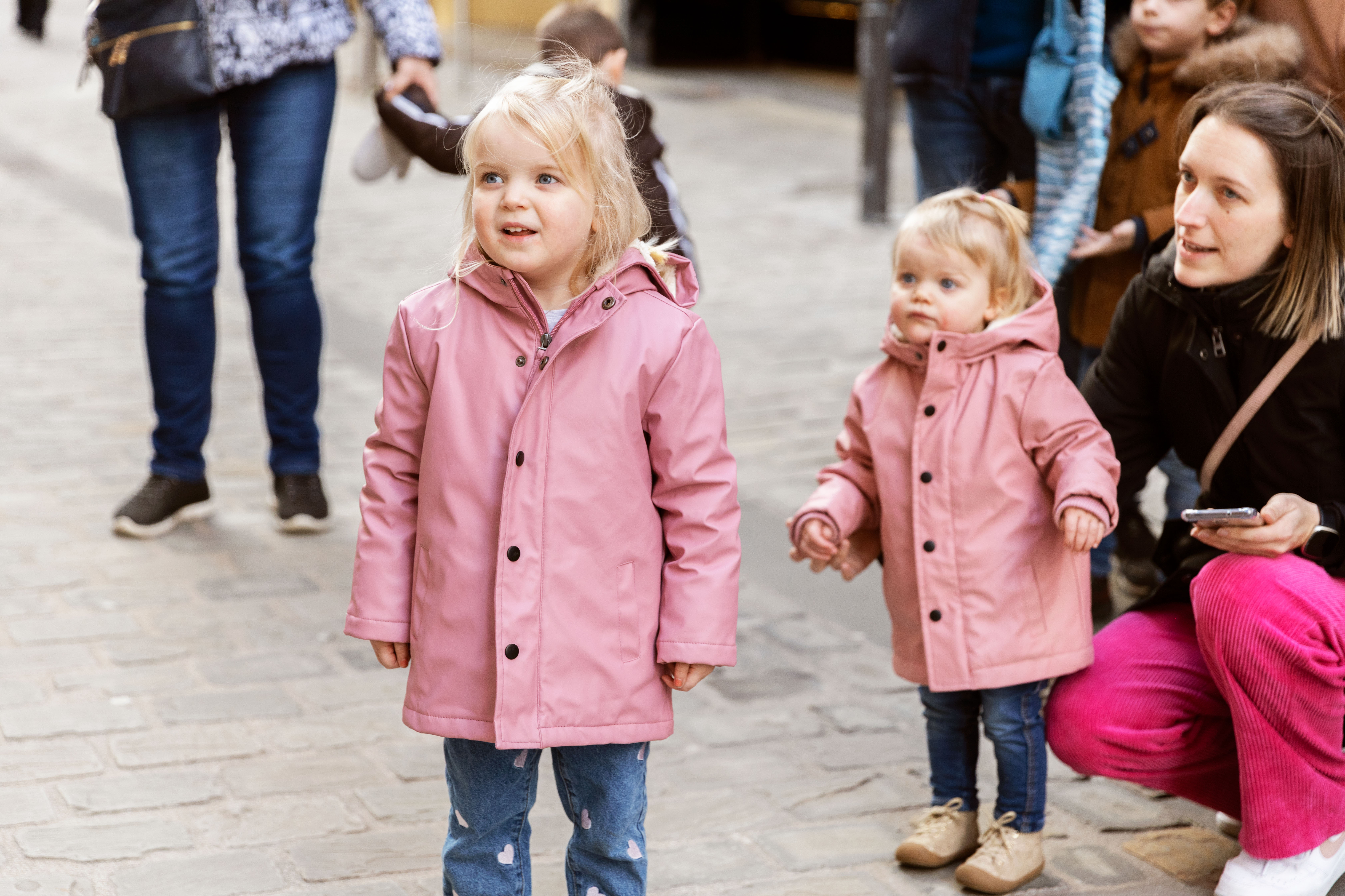 Een foto van twee blonde kindjes die naar Rikki kijken.