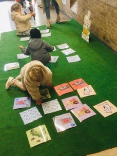Drie kinderen spelen memory van Rikki op een grasmat. Deze foto werd genomen op de Rikki belevingsnamiddag in Brugge in 2024.