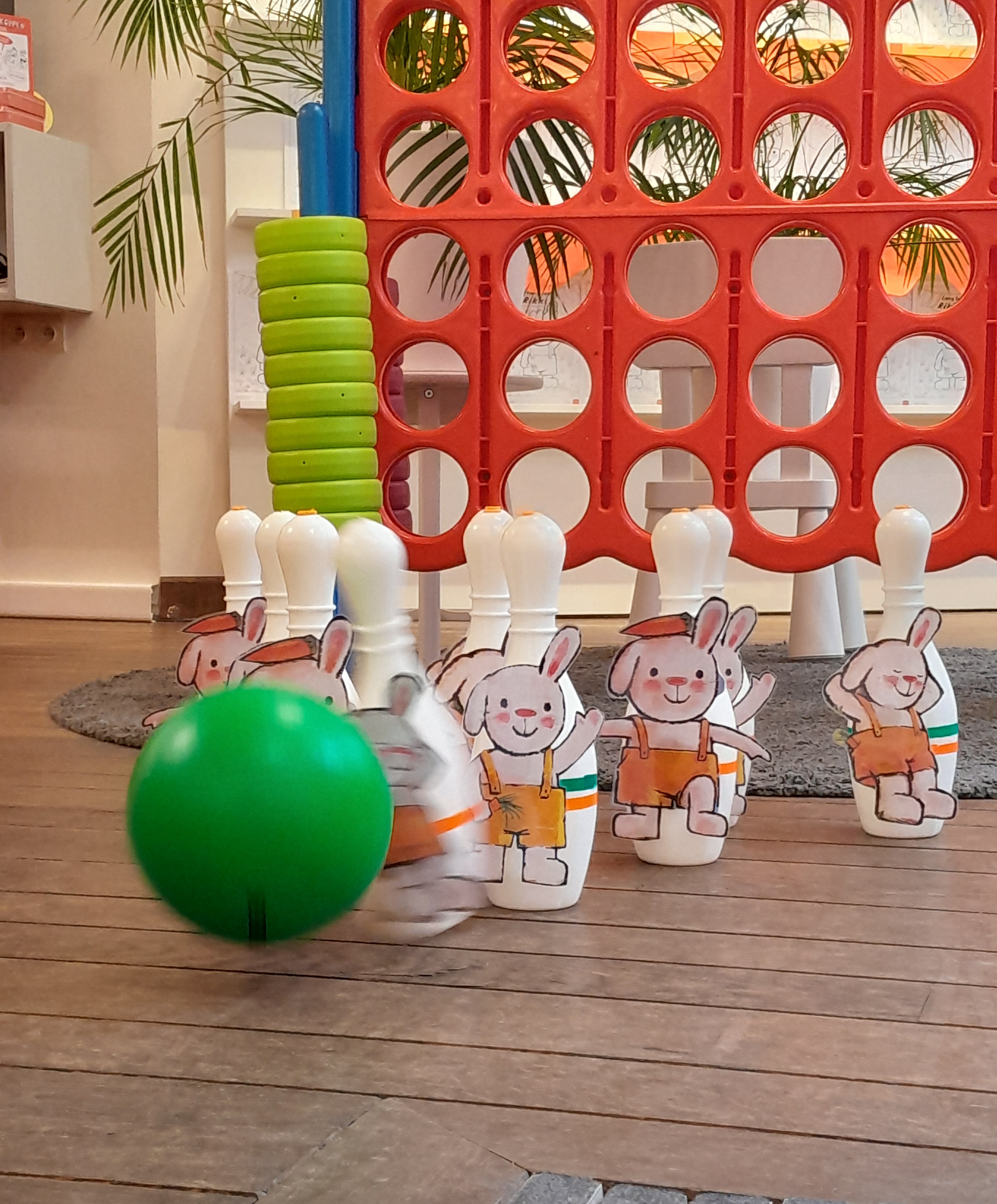 We zien een zelfgemaakt bowlingspel van Rikki. Op elk kegeltje hangt een illustratie van Rikki geplakt. 