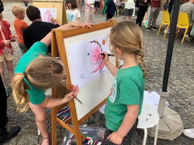 kind tekent een gezichtje op een schildersezeltje