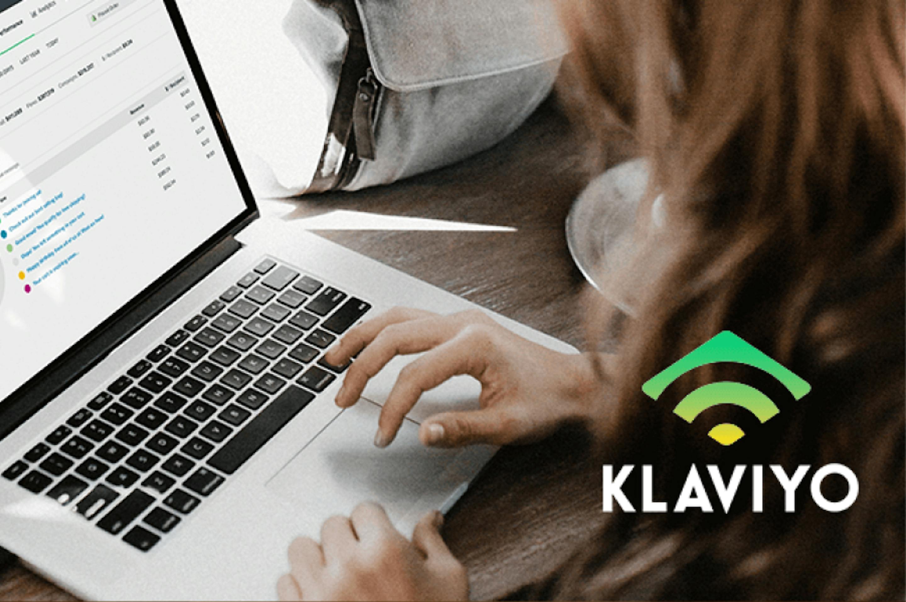 Person typing on a laptop with a Klaviyo logo in the corner