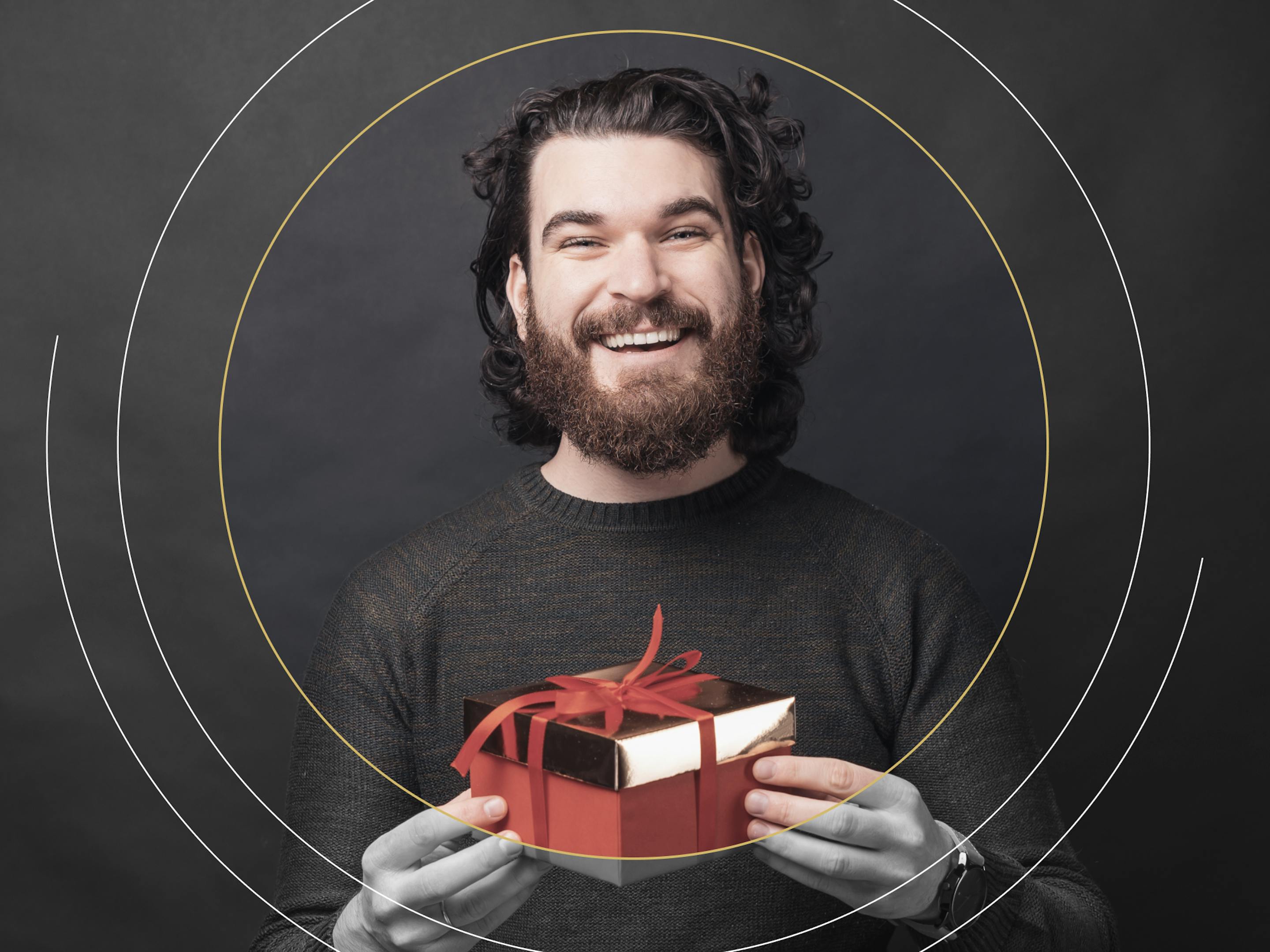 man smiling and holding red gift box