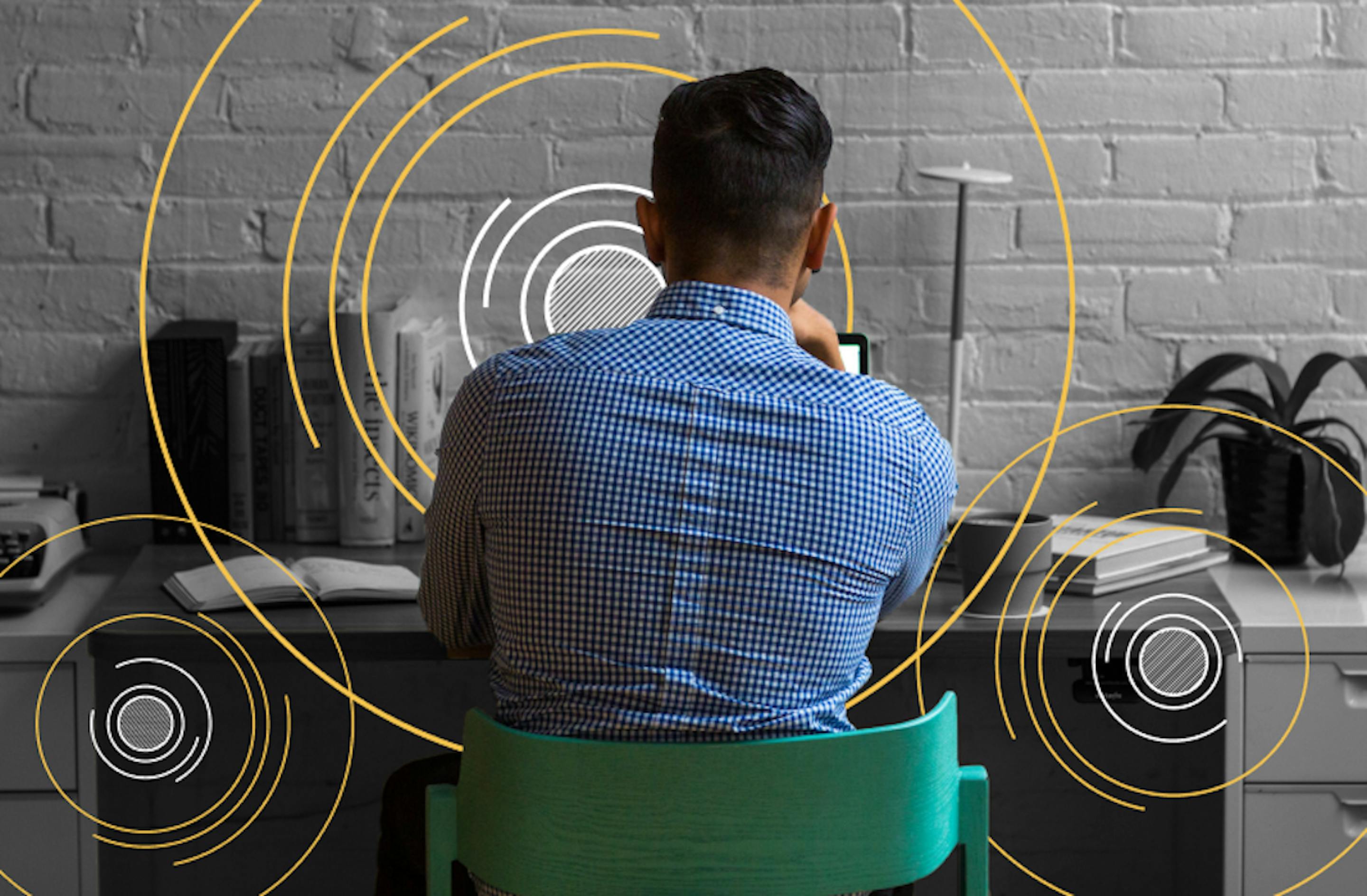 A man is sitting beside his desk working