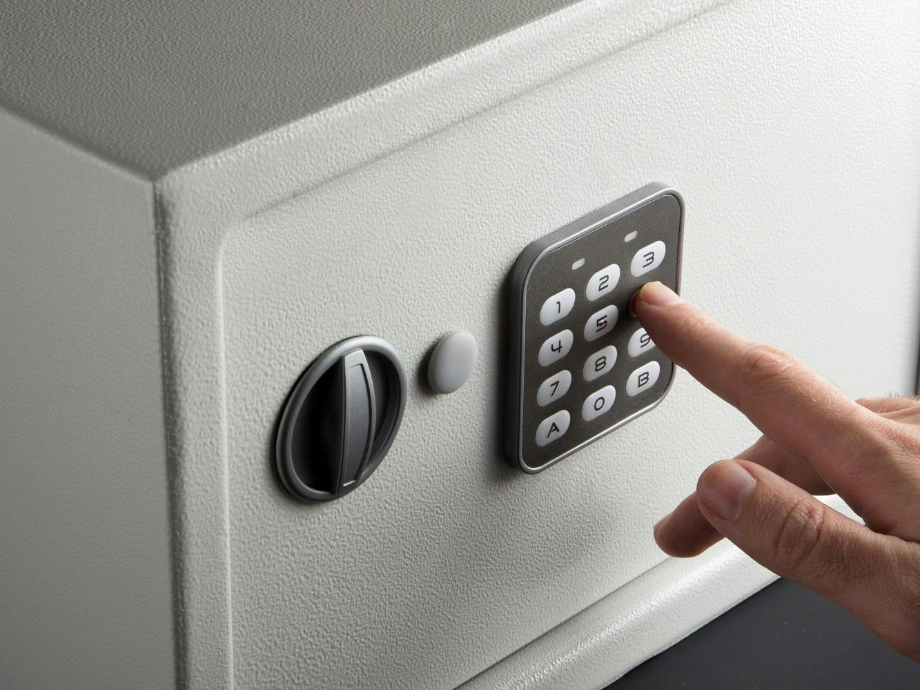 Closeup of a hand entering a code to open a safe
