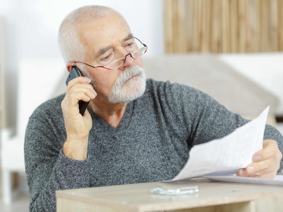 Man on phone holding a bill