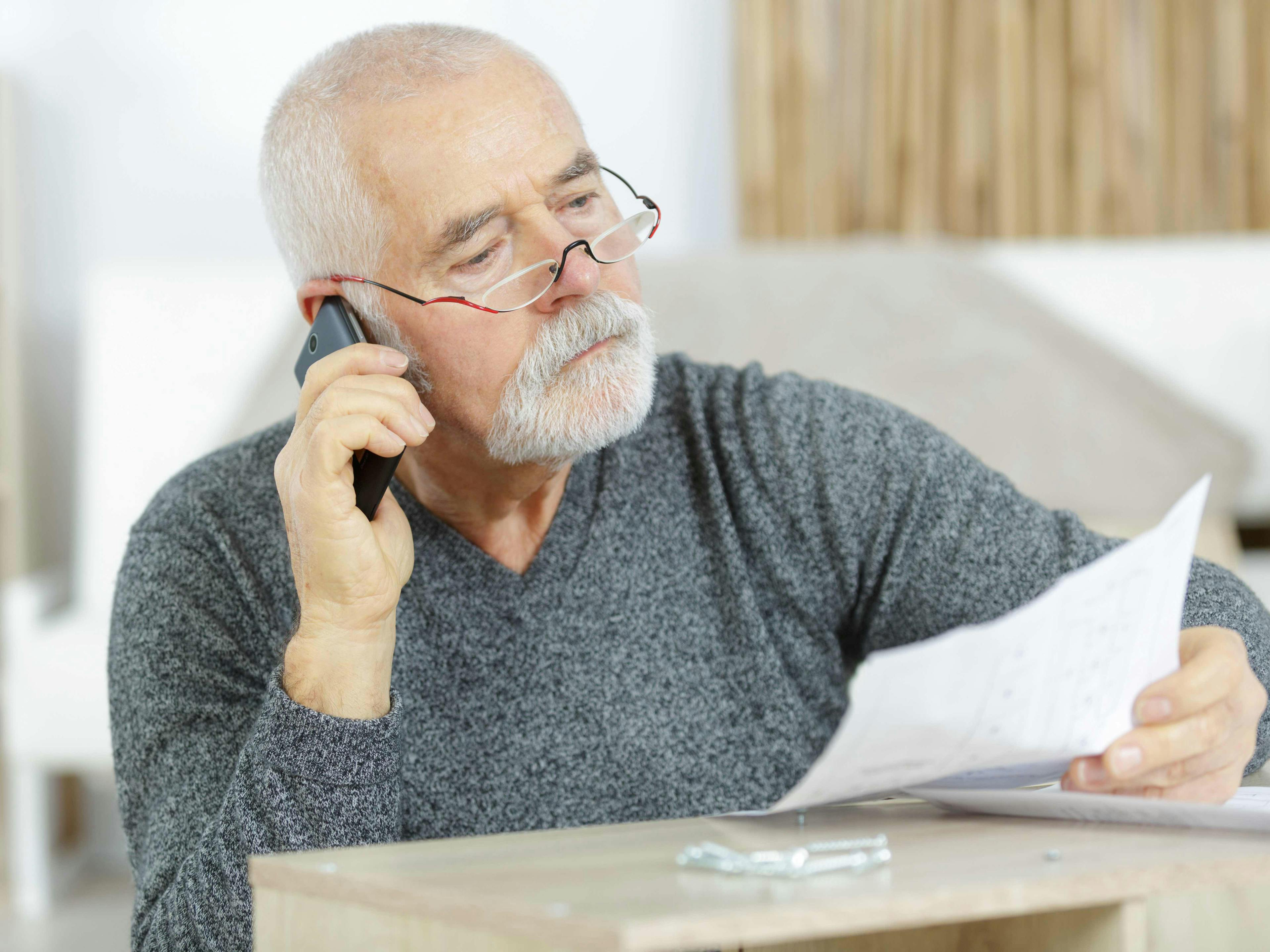 Man on phone holding a bill