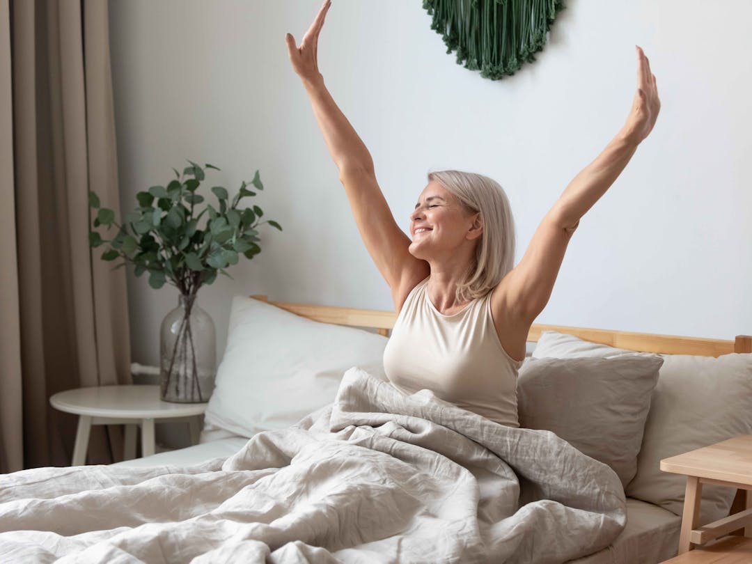 woman in bed stretching