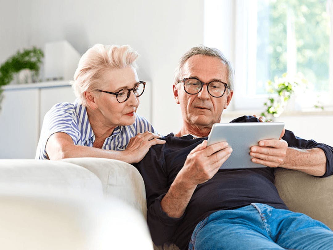 Couple on the couch looking at tablet