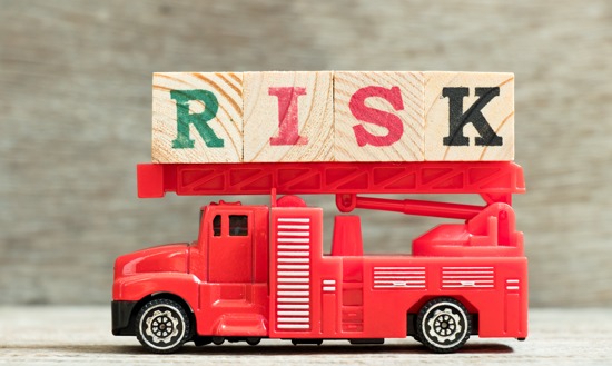 Toy firetruck with the word RISK spelled in wooden blocks