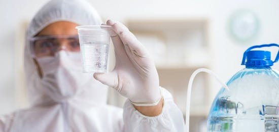person in PPE conducting water tests