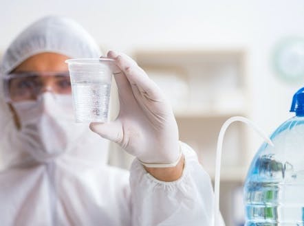 person in PPE conducting water tests