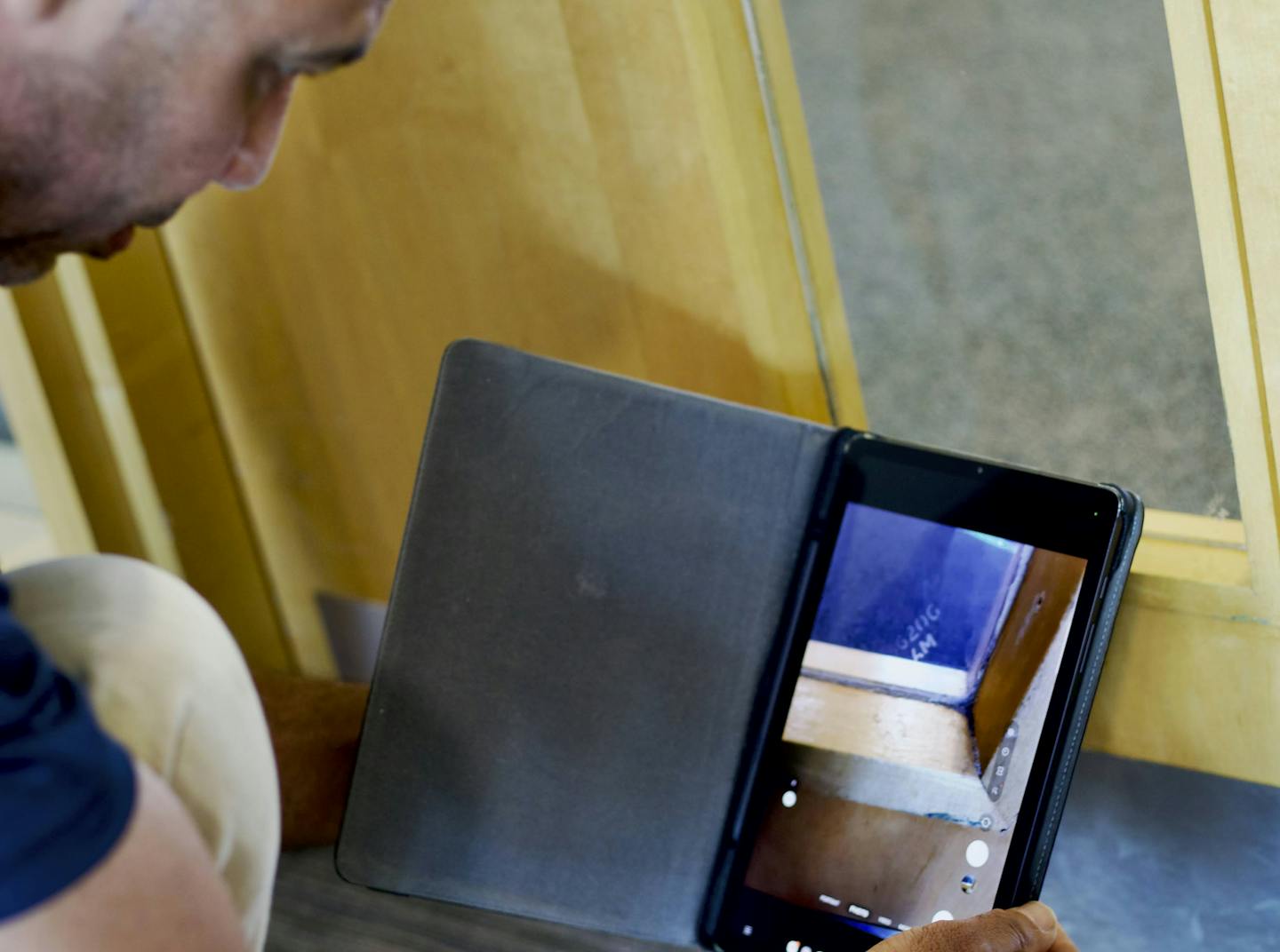 Inspector using a handheld device to take photo of fire door