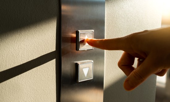 Person pressing button to call a lift