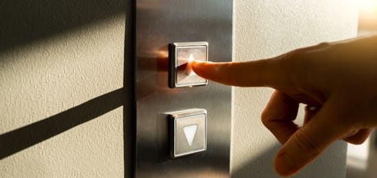 Person pressing button to call a lift