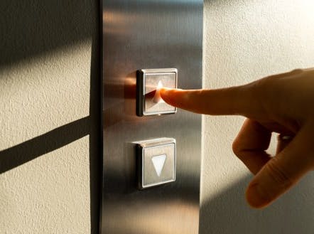 Person pressing button to call a lift