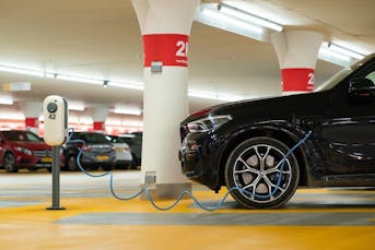 Electric car getting charged in a parking lot
