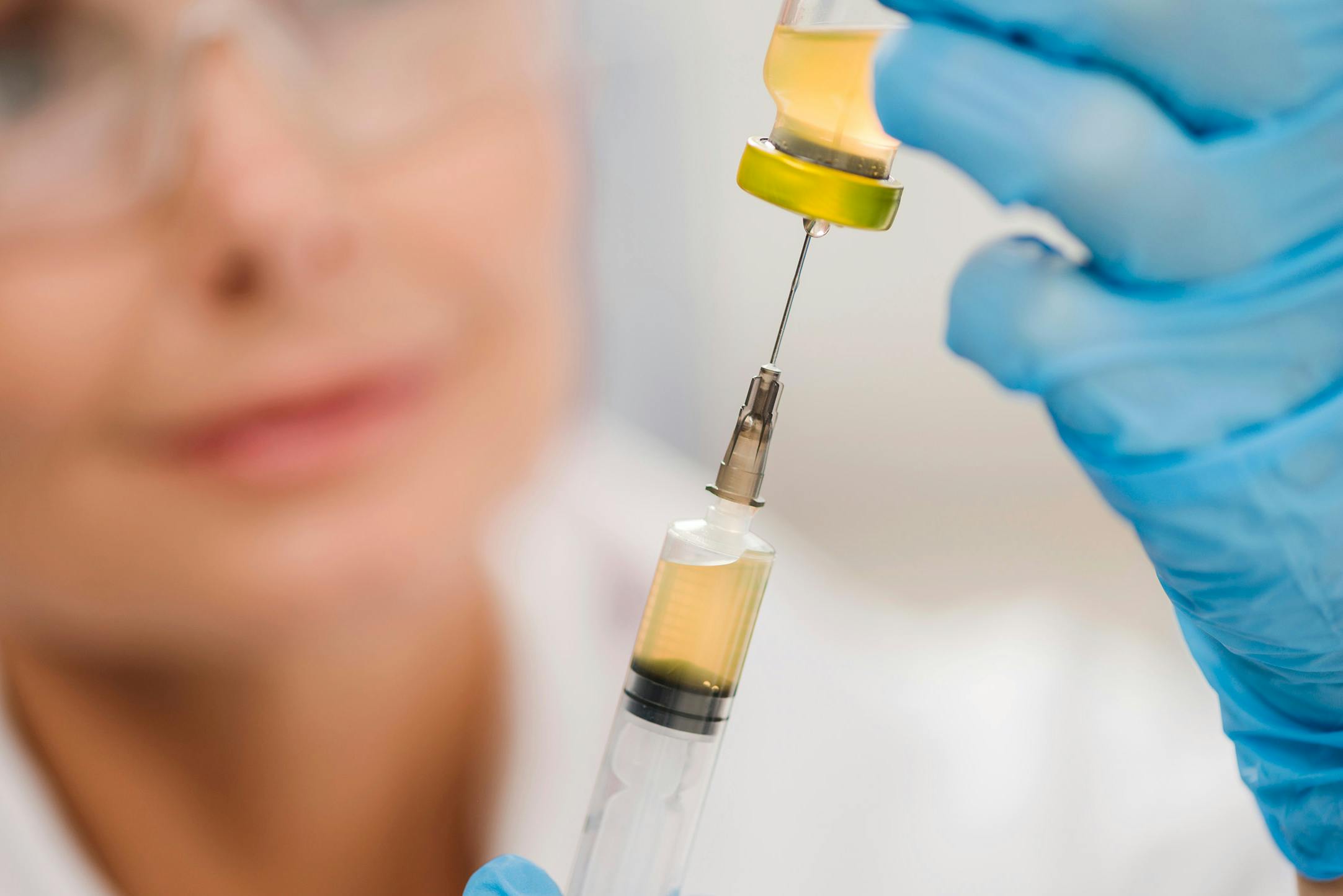 A clinician holding a Vitamin B12 syringe