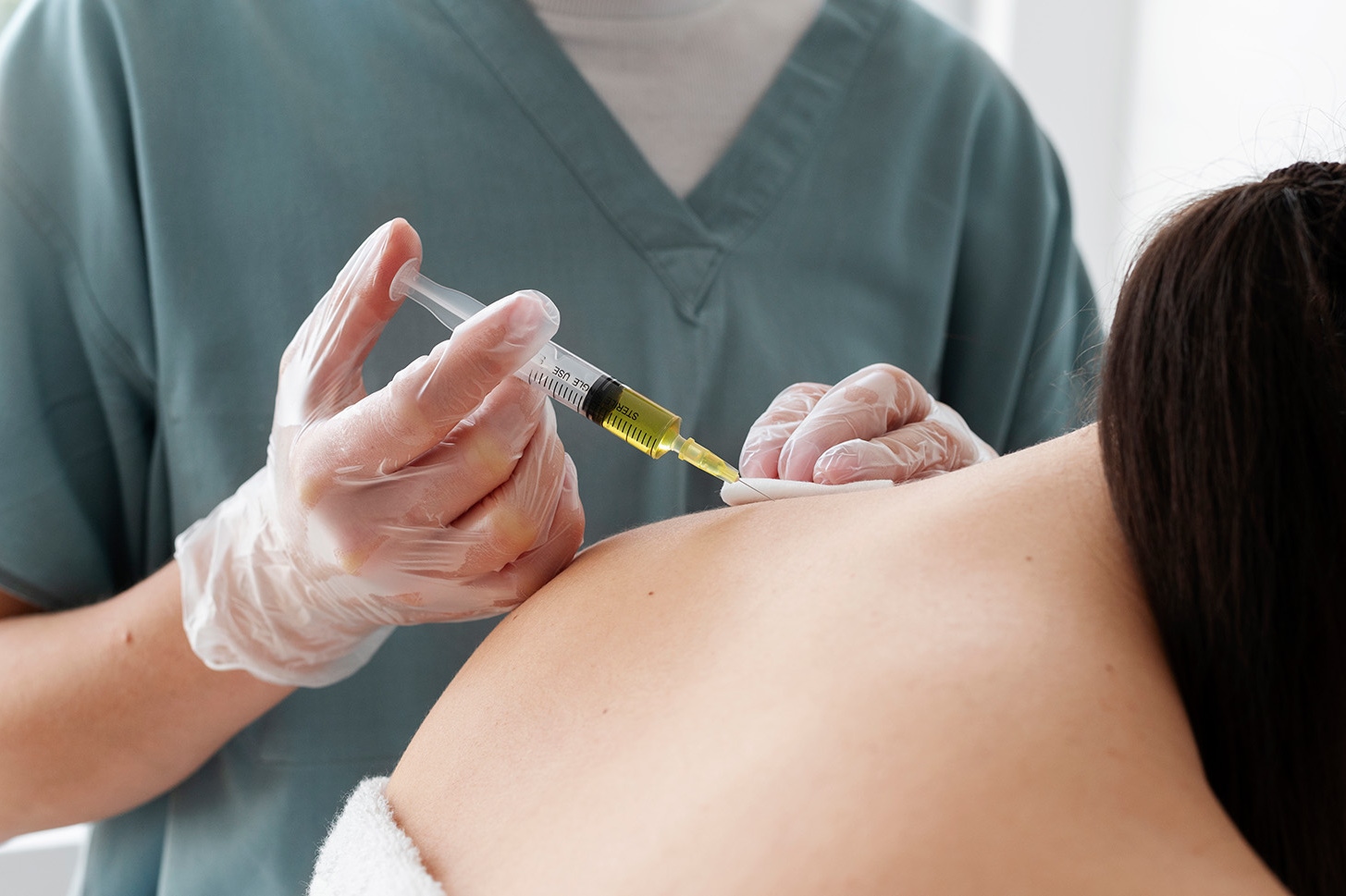 Female patient receiving trapezius botox injections