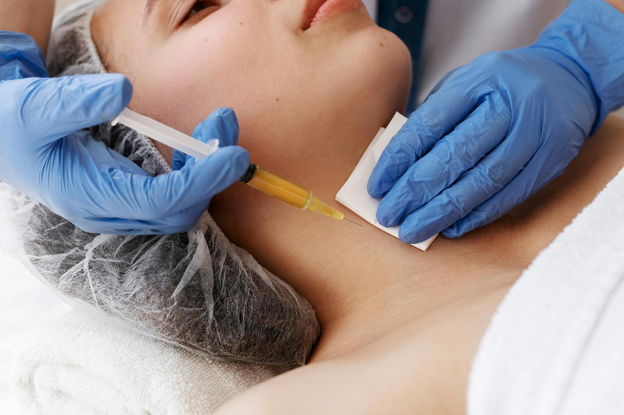 A female patient receiving Polynucleotides treatment on the neck area