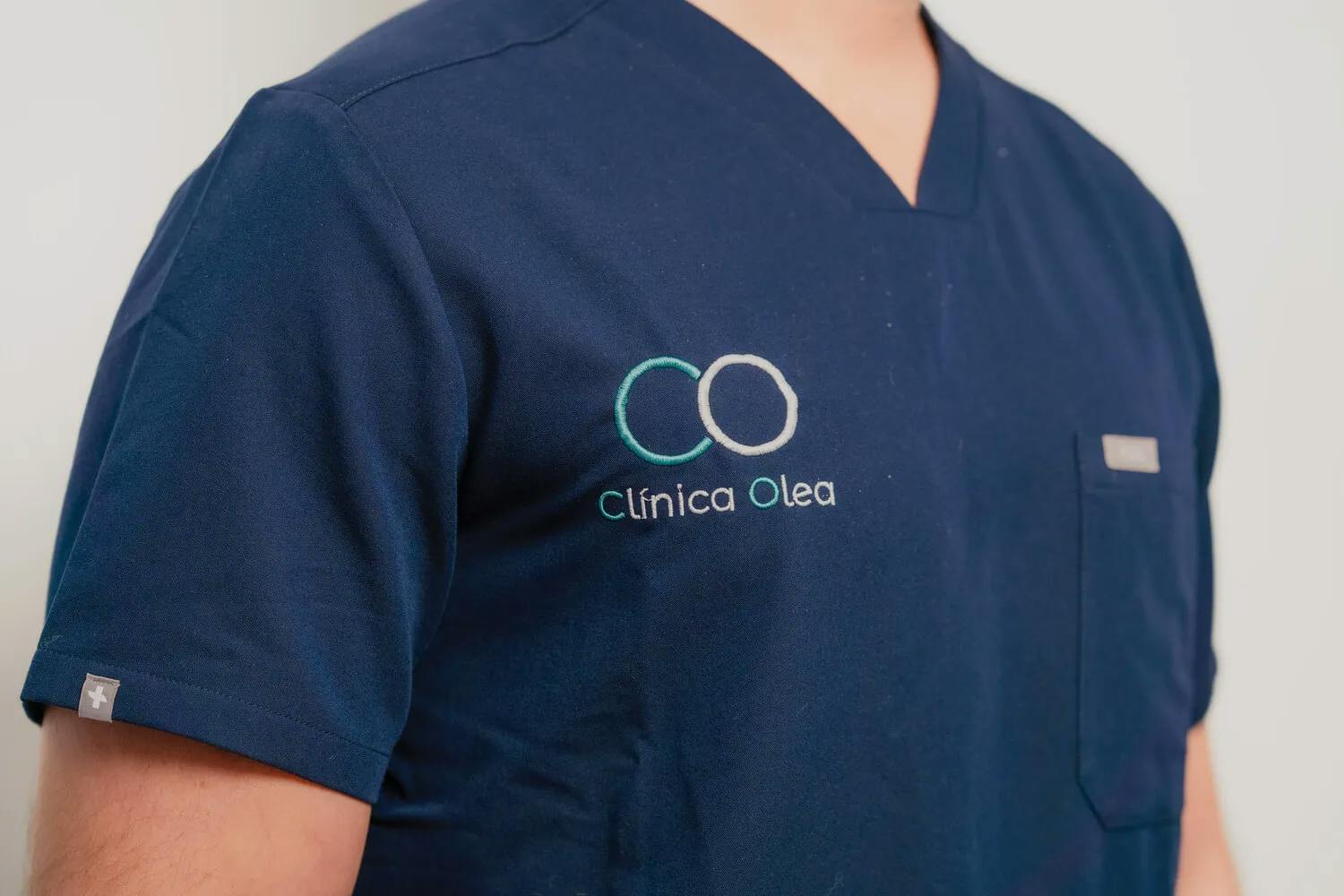 Torso con camiseta corporativa de Clínica Olea