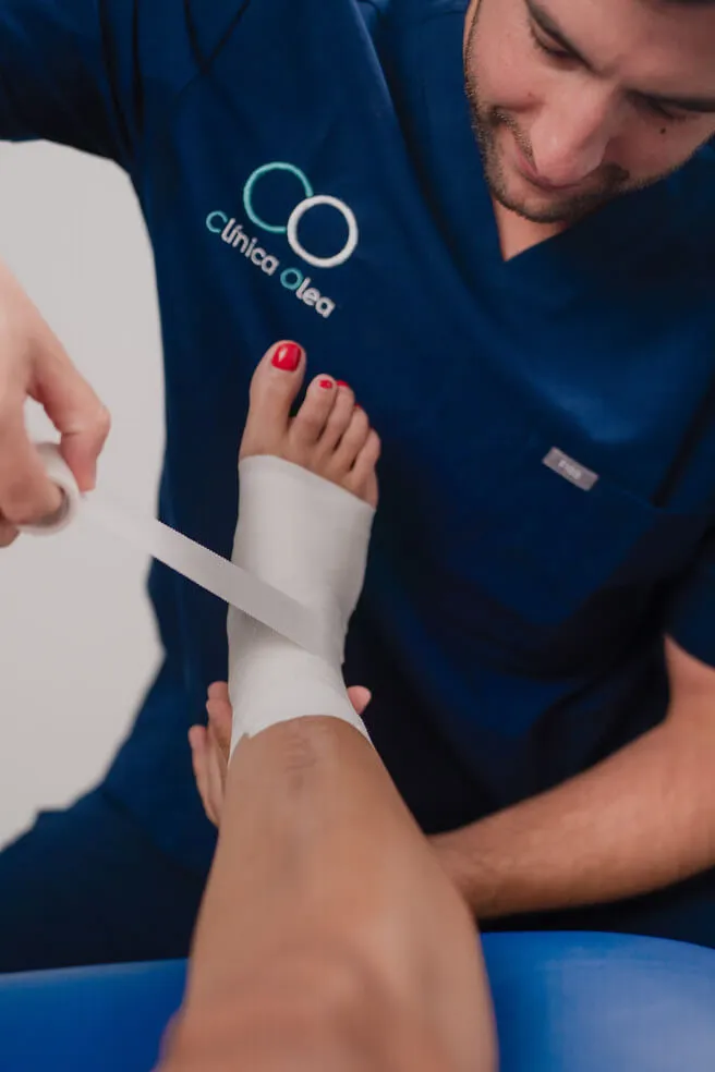 Fisioterapeuta de Clínica Olea vendando un tobillo