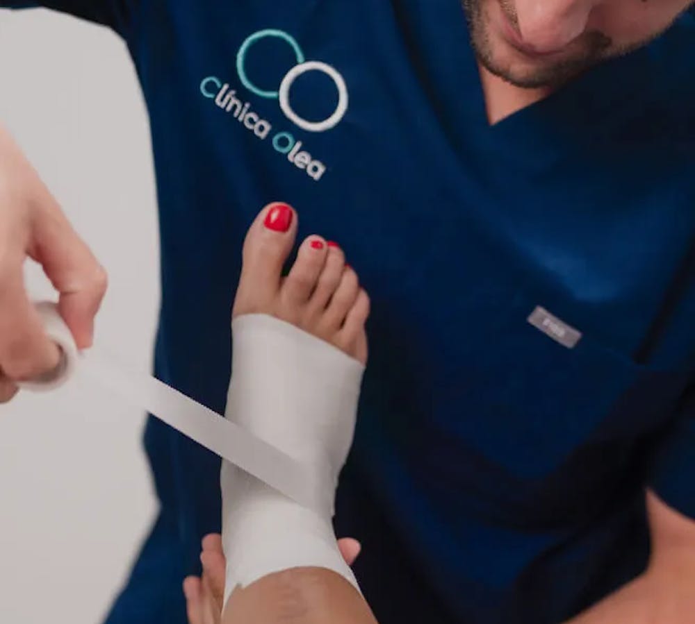 Fisioterapeuta de Clínica Olea vendando un tobillo