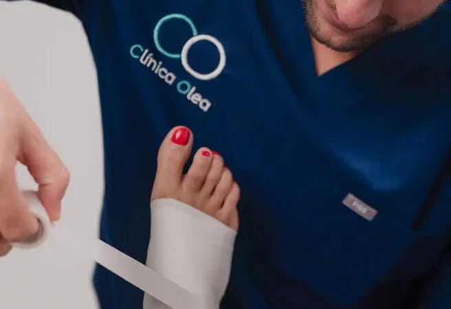 Fisioterapeuta de Clínica Olea vendando un tobillo