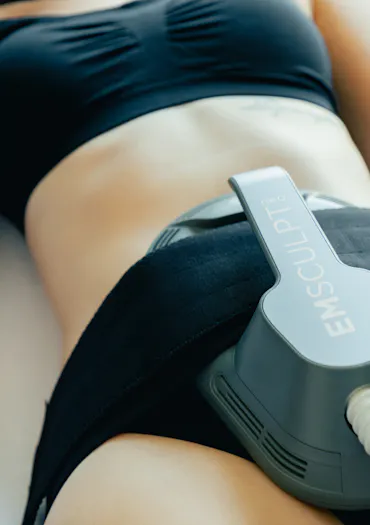 Experte du CEMF Lyon Vienne qui réalise une séance d'EMSculpt Neo sur le ventre d'une patiente pour tonifier la sangle abdominale.