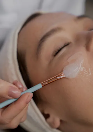 Experte du CEMF qui réalise un peeling sur le visage d'une patiente.