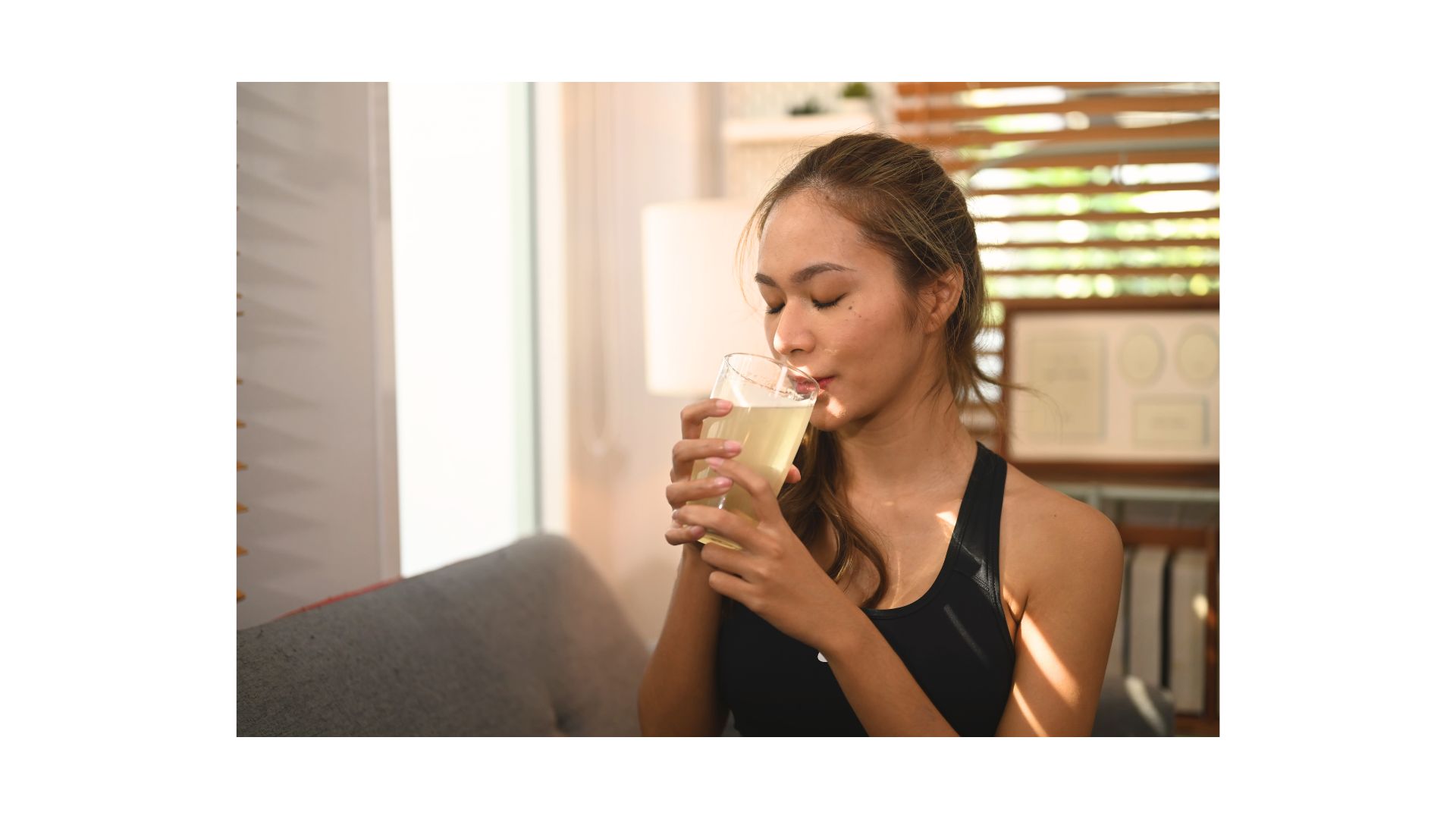 Jeune femme brune qui est en train de boire une boisson qui contient du collagène. 