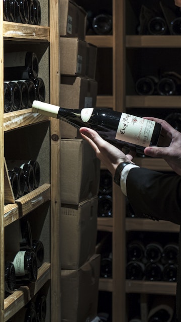 le sommelier Thomas Lorival choisit une bouteille dans la cave à vin