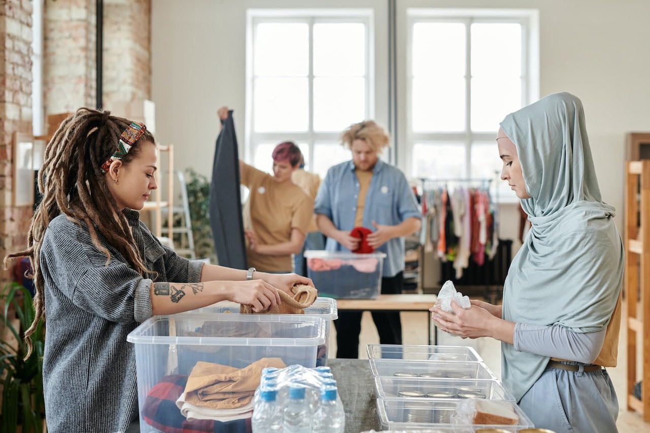 women organizing clothes into bins