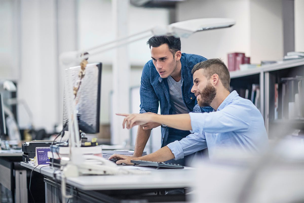 men working on a laptop together