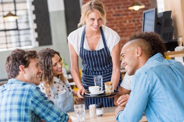 waitress serving a group at a restaurant table