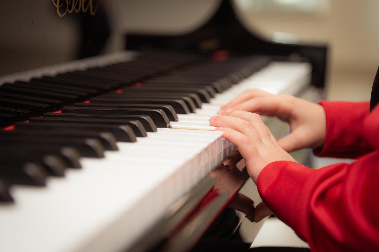 kid's hands playing piano
