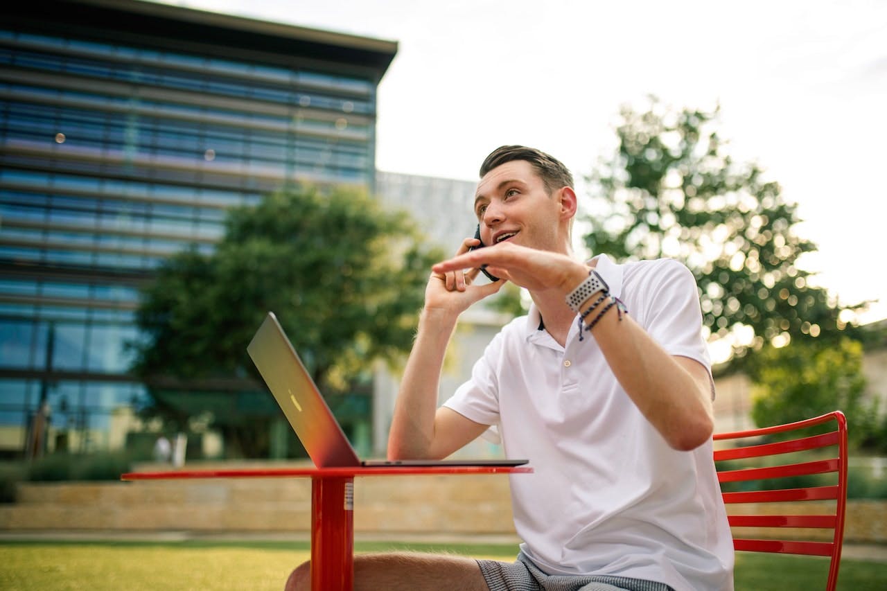 man talking on a cell phone with a laptop