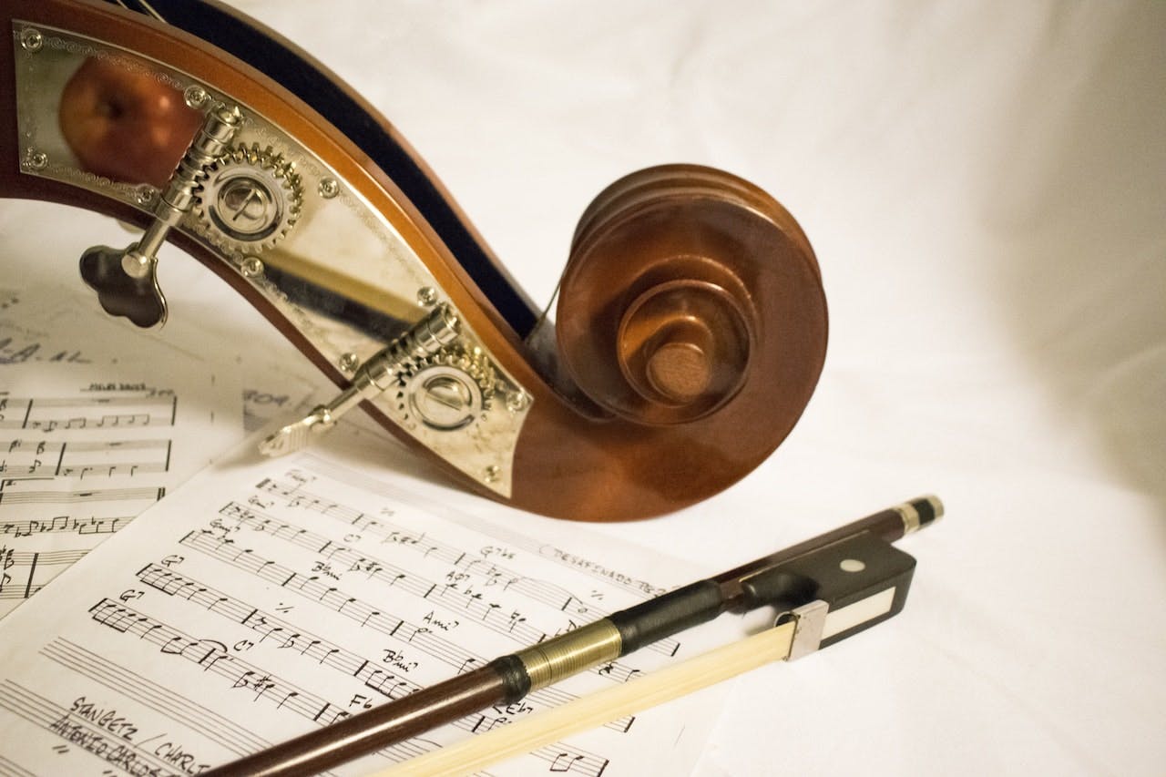 sheet music and bow and scroll of a cello