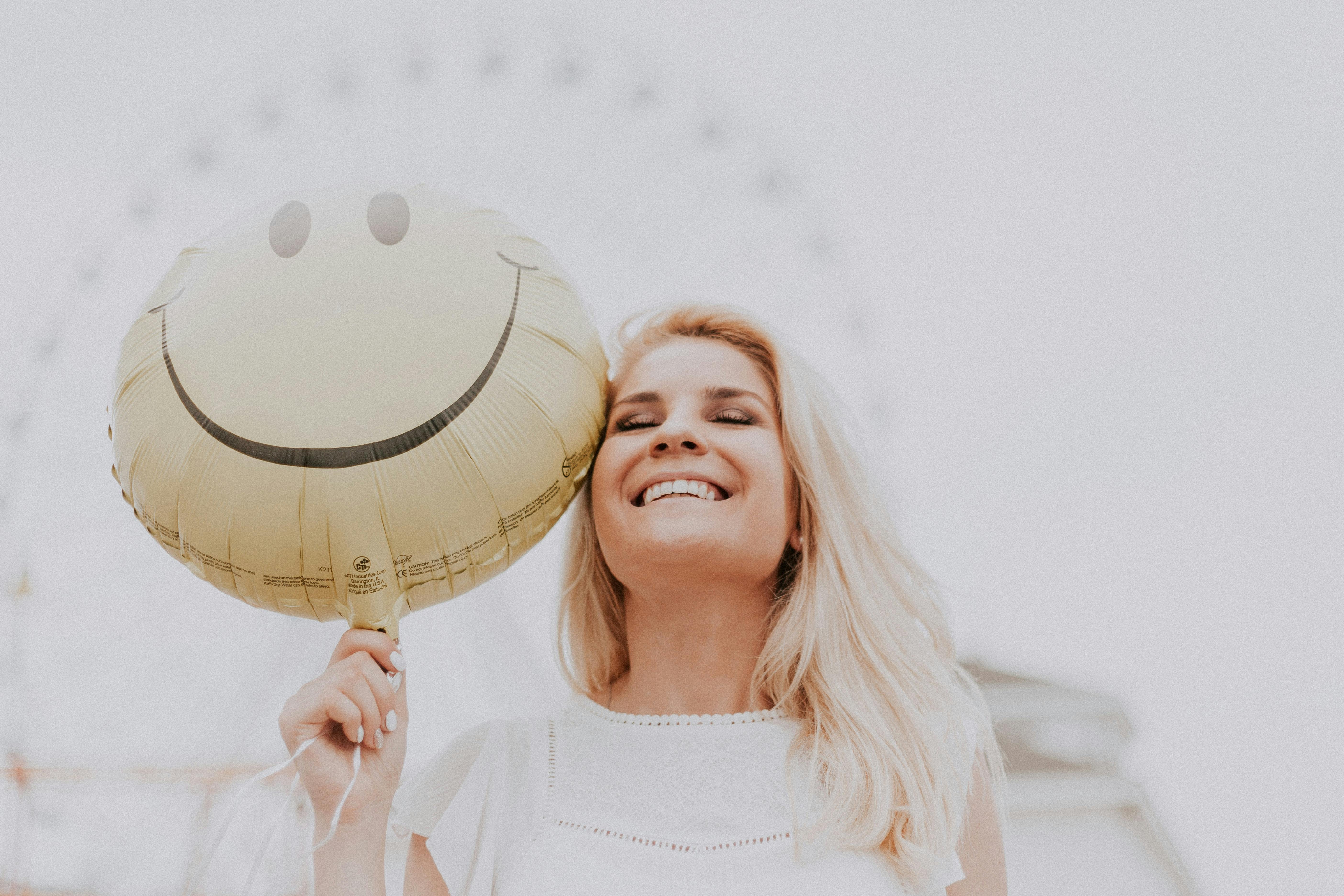 woman smiling with smiley face balloon