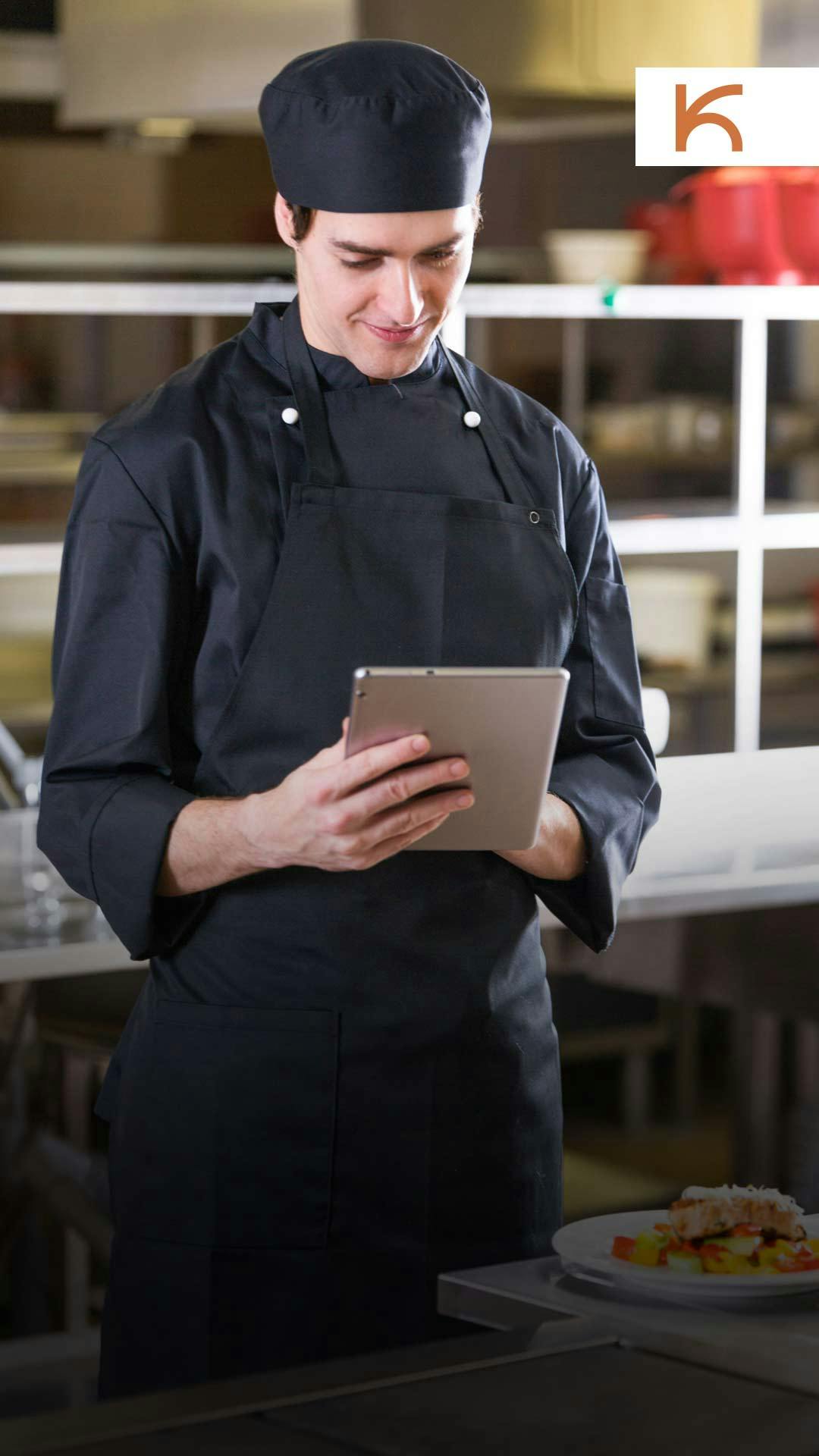 cozinheiro de uniforme preto conferindo empratamentos enquanto se satisfaz com resultado da recuperação de vendas