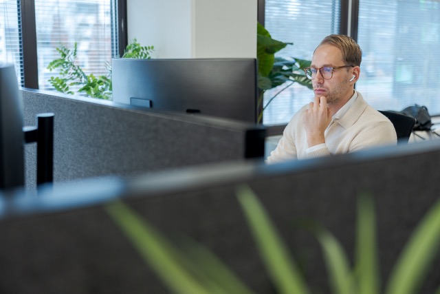Hugo geconcentreerd aan het werk achter zijn bureau op het kantoor van Cloud++