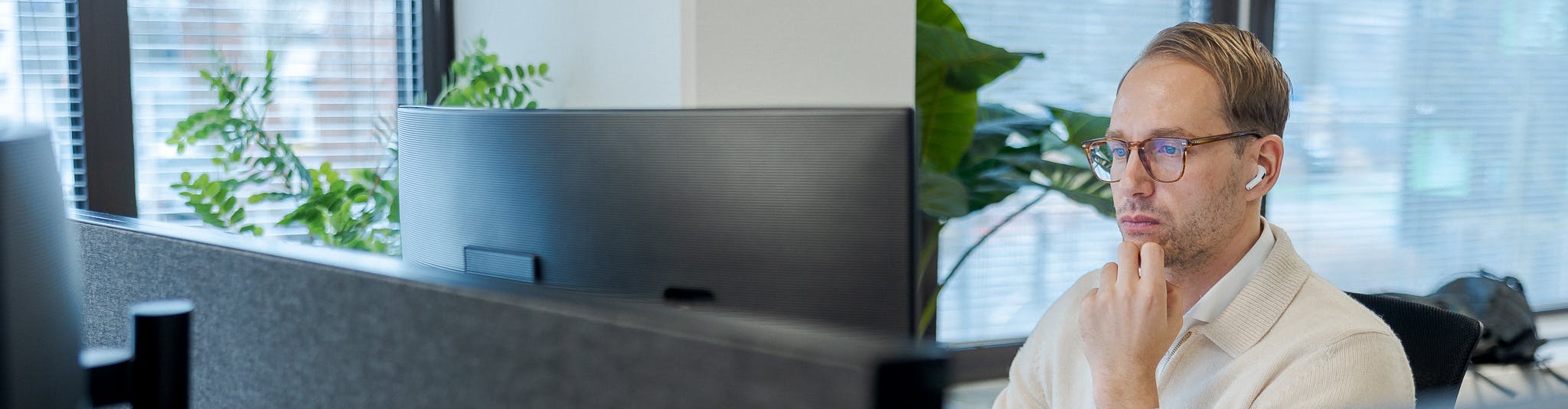 Een foto van Hugo, werkt achter zijn bureau op het kantoor van Cloud++