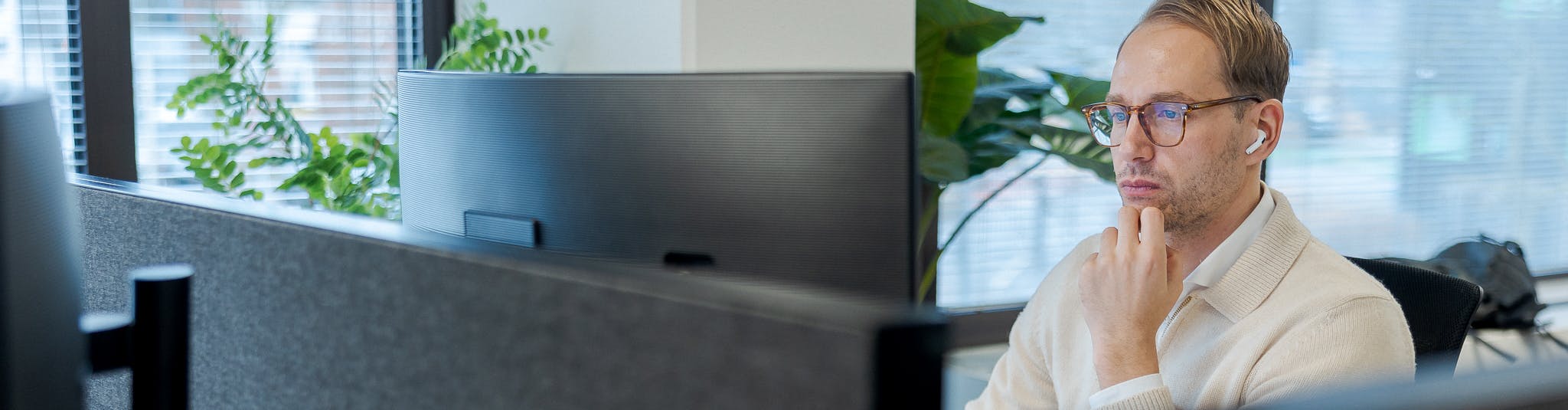 Een foto van Hugo, werkt achter zijn bureau op het kantoor van Cloud++