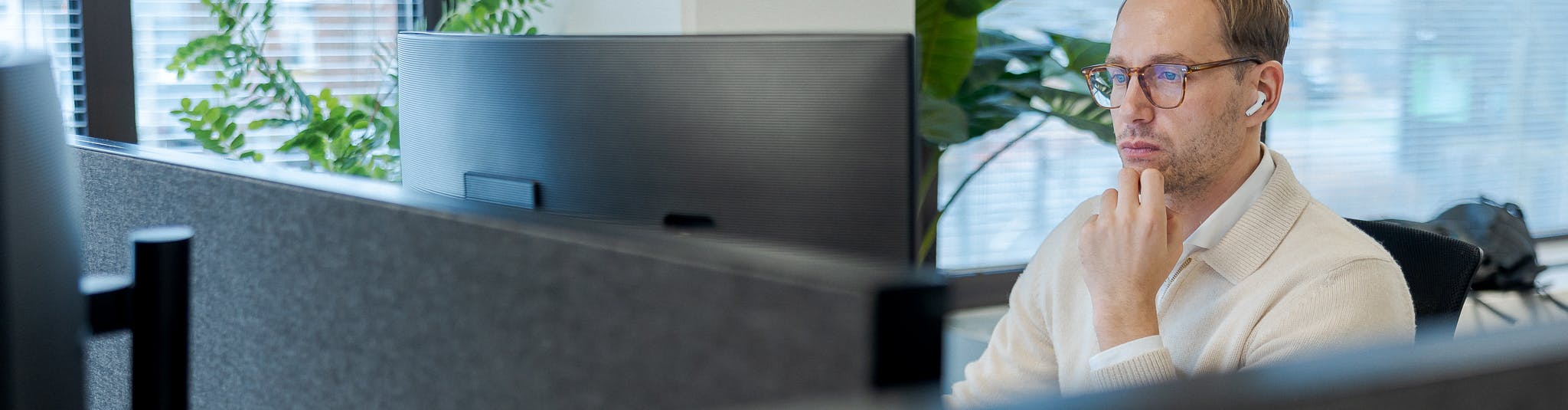 Een foto van Hugo, werkt achter zijn bureau op het kantoor van Cloud++