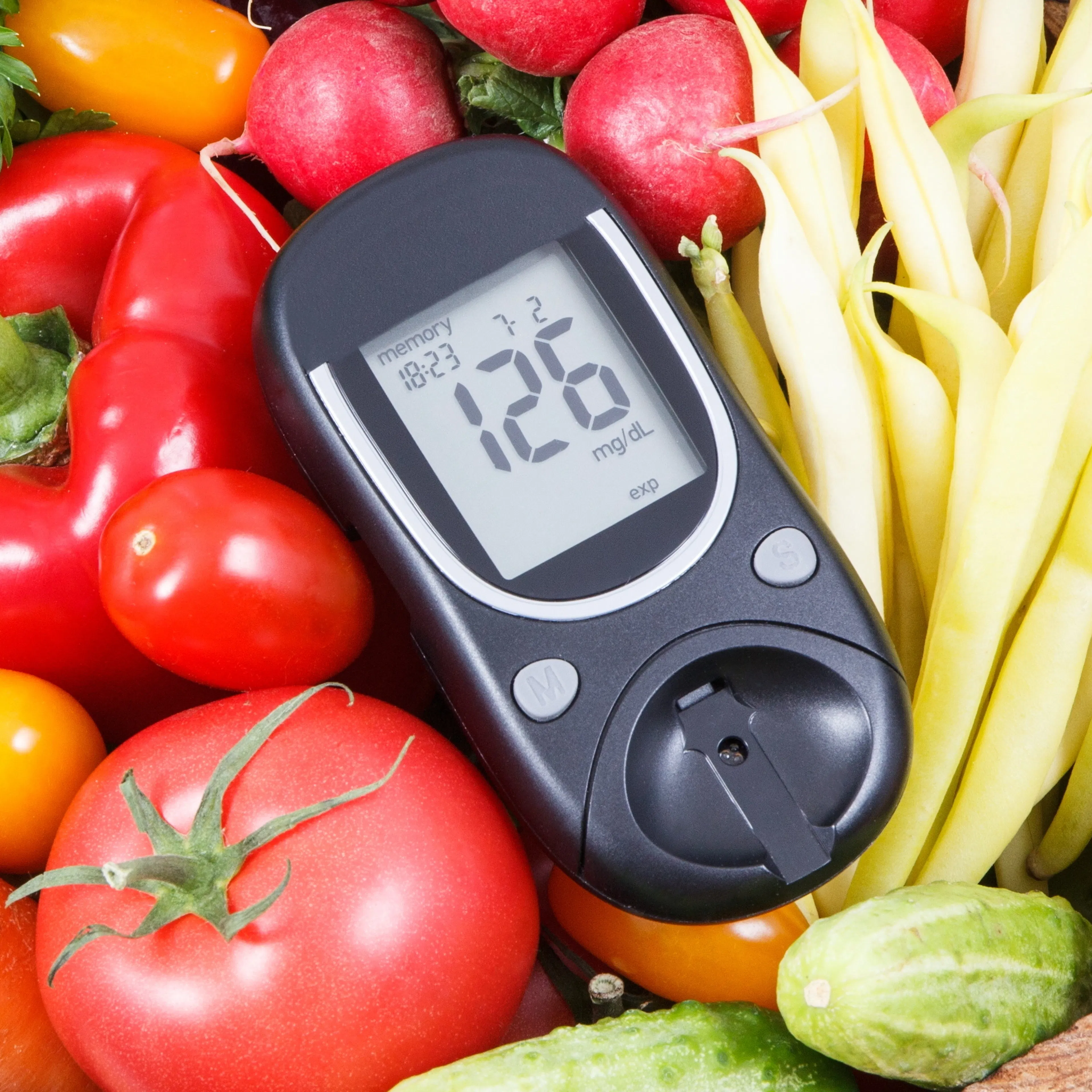 A glucometer used by diabetics is depicted with vegetables. 