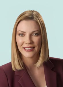 CLS Health's COO, Misty Berger, posing for her headshot in a burgundy blazer.
