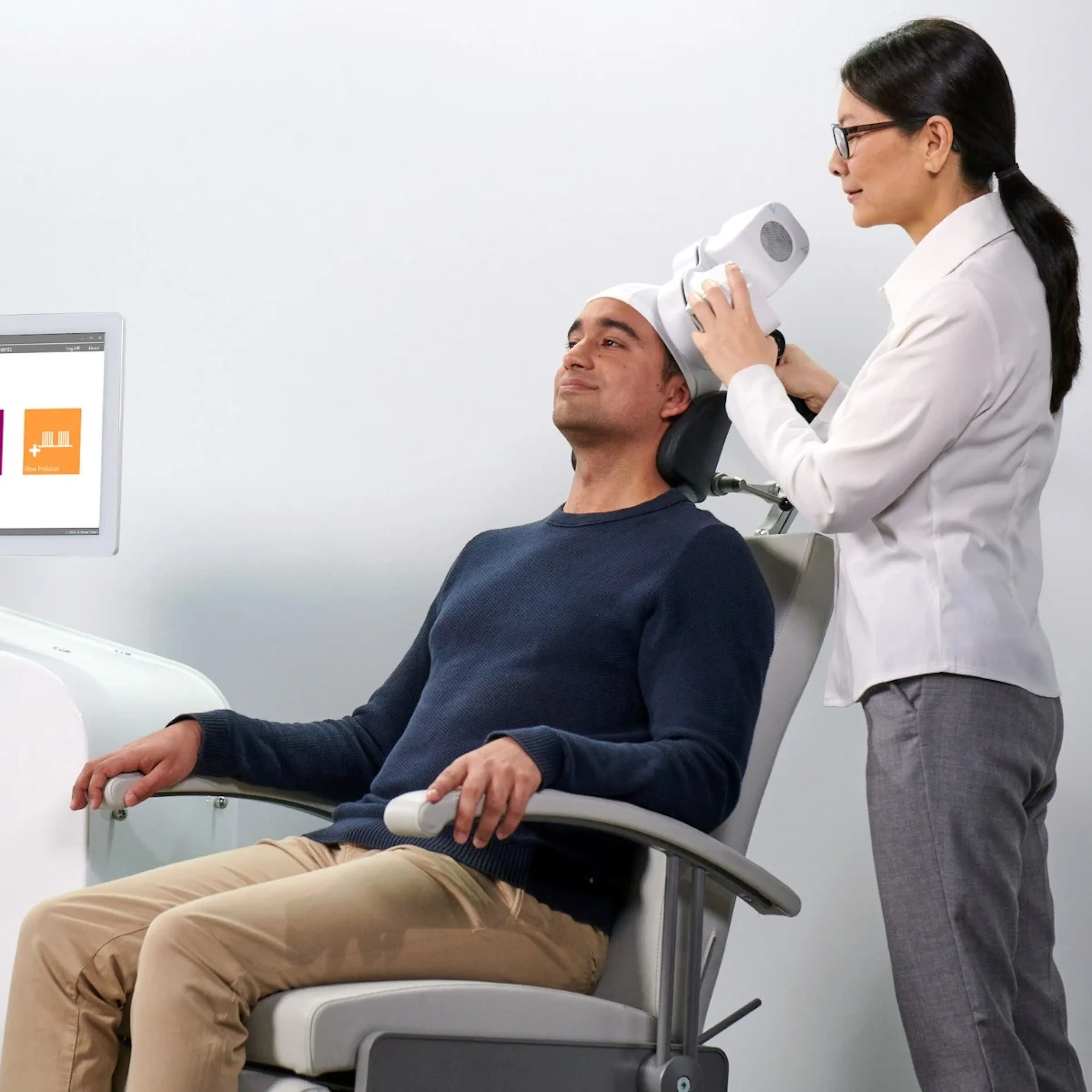 A man is receiving Transcranial Magnetic Stimulation (TMS) therapy to combat depression.