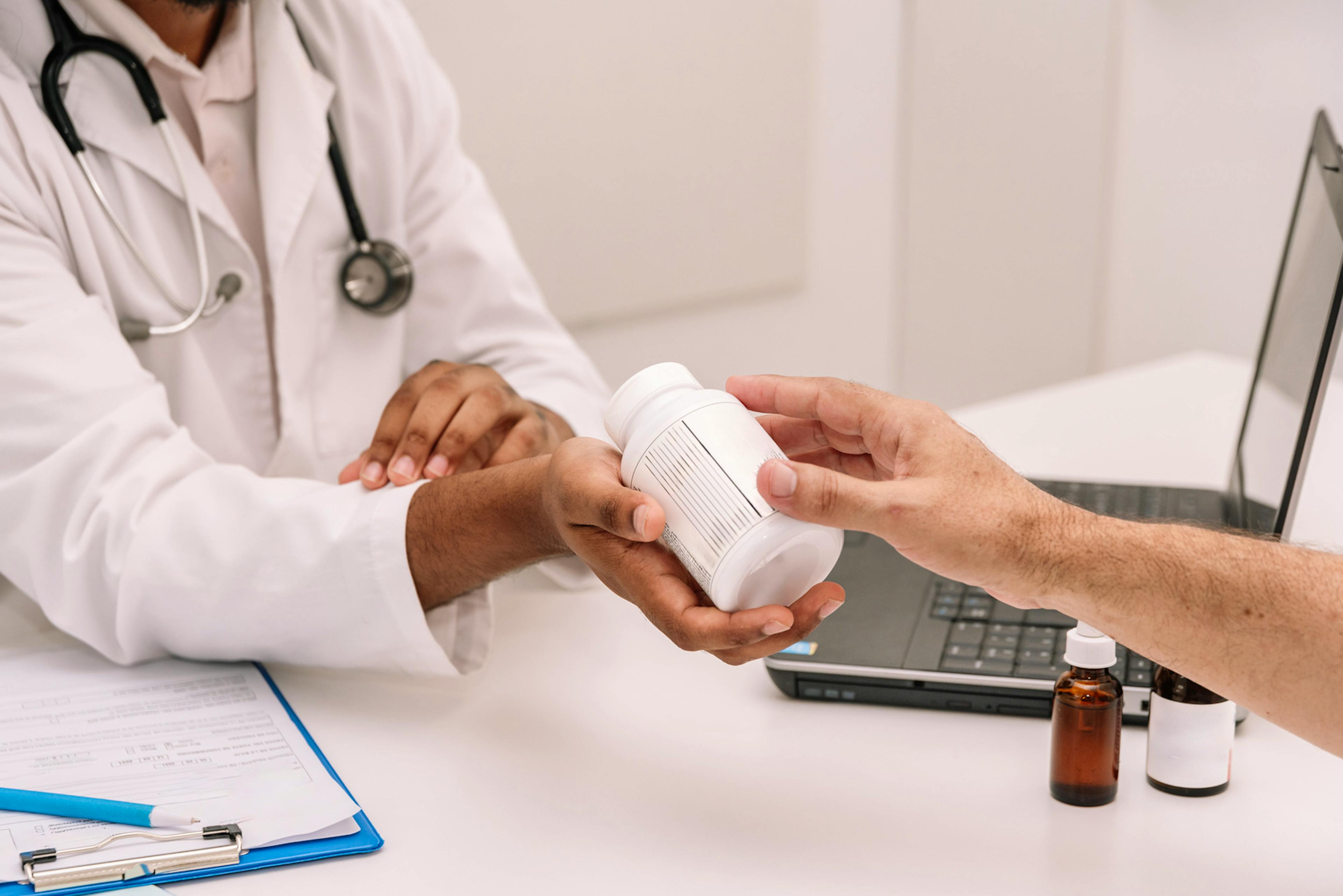 Cropped doctor giving medical pills to patient.
